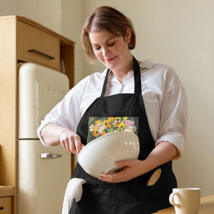 Tablier de cuisine artistique élégant avec impression florale porté pendant la préparation d’un gâteau.