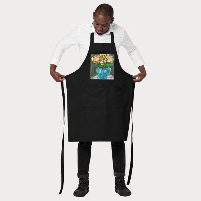 Tablier de cuisine artistique ajustable noir mettant en valeur un bouquet fleuri dans un vase turquoise.
