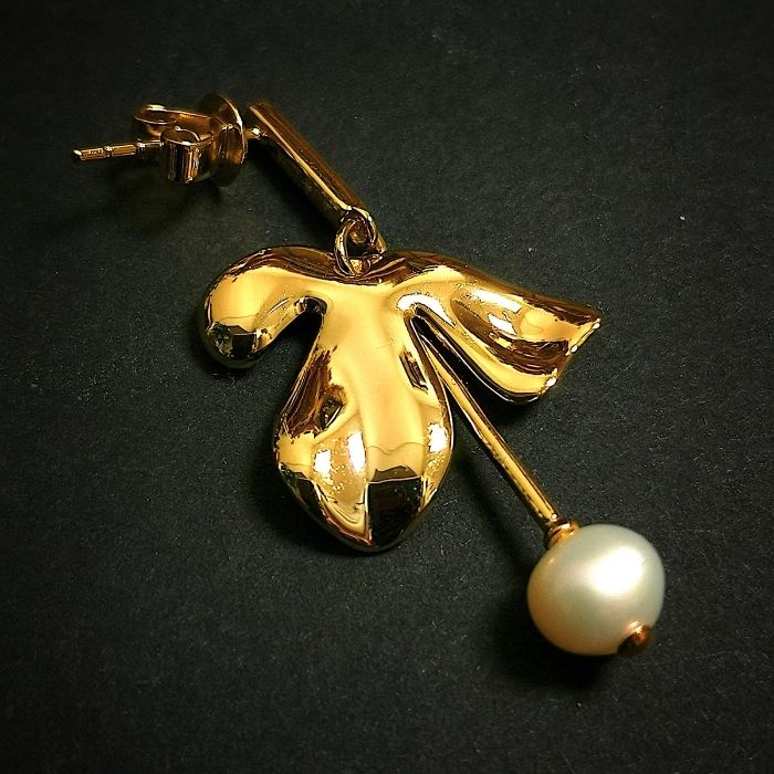 Vue rapprochée d’une Boucle d’oreilles Trèfle, détail des feuilles dorées et de la perle raffinée pour offrir