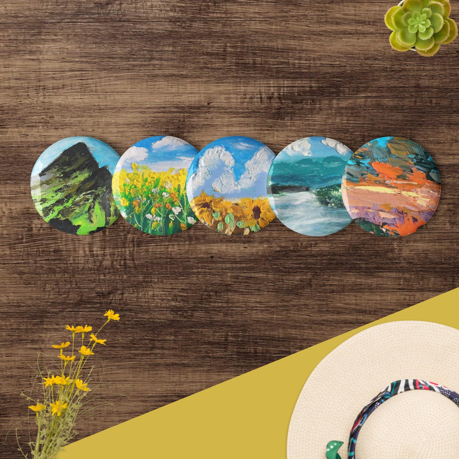 Set de pins paysages peints à la main, présentation soignée sur table en bois clair